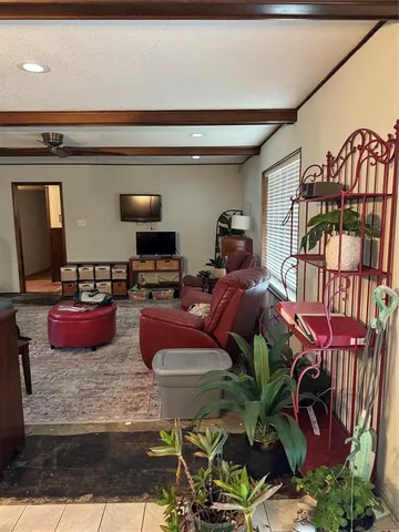 a living room with furniture a flat screen tv and kitchen view