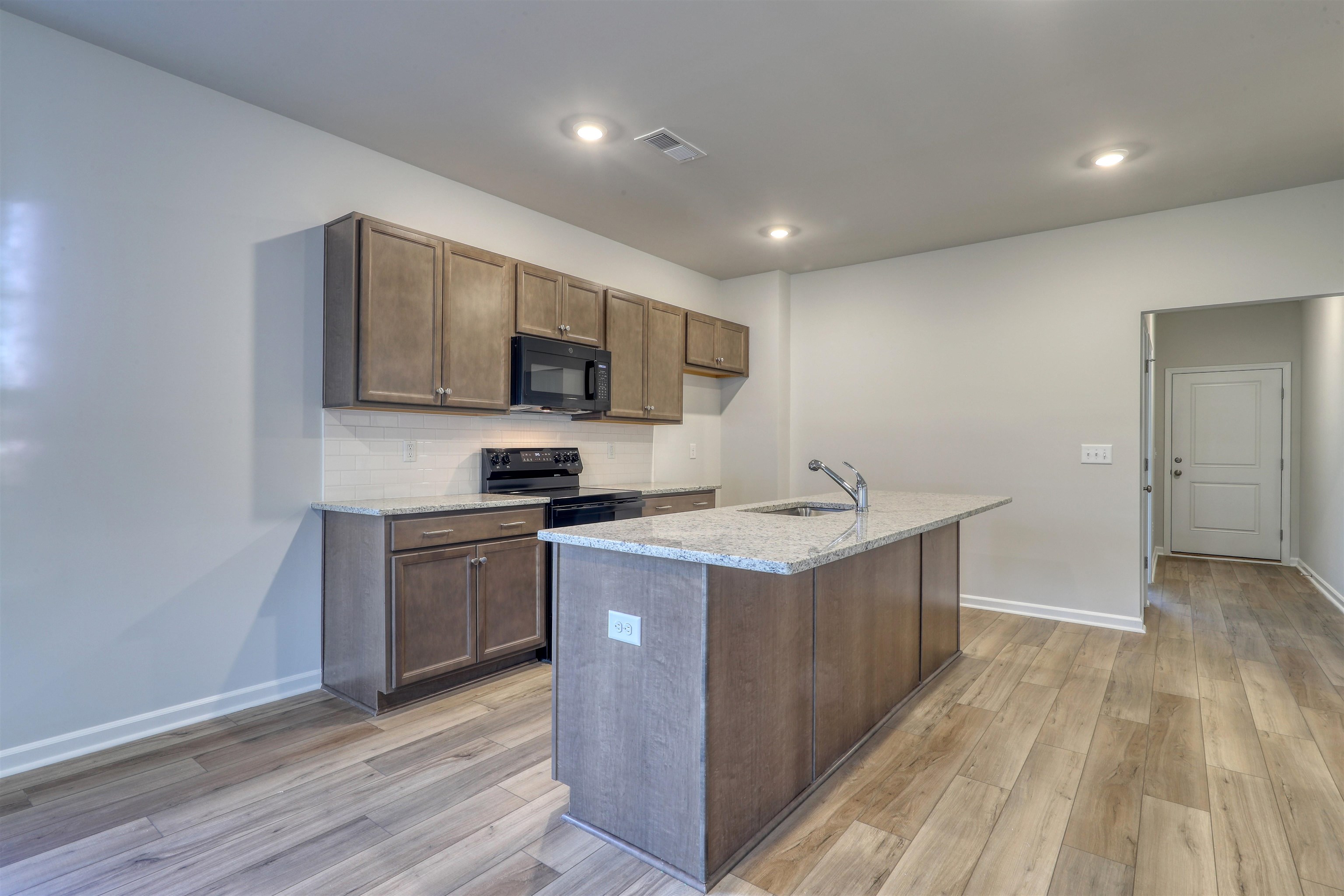 3431 Logan Street Conway, SC 29526 - Photo 9 of 31 Kitchen with light stone countertops, black appliances, backsplash, light wood-style flooring, and recessed lighting