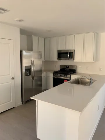a kitchen with stainless steel appliances a refrigerator sink and microwave
