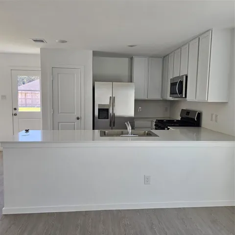 a kitchen with stainless steel appliances granite countertop a sink a stove and a refrigerator