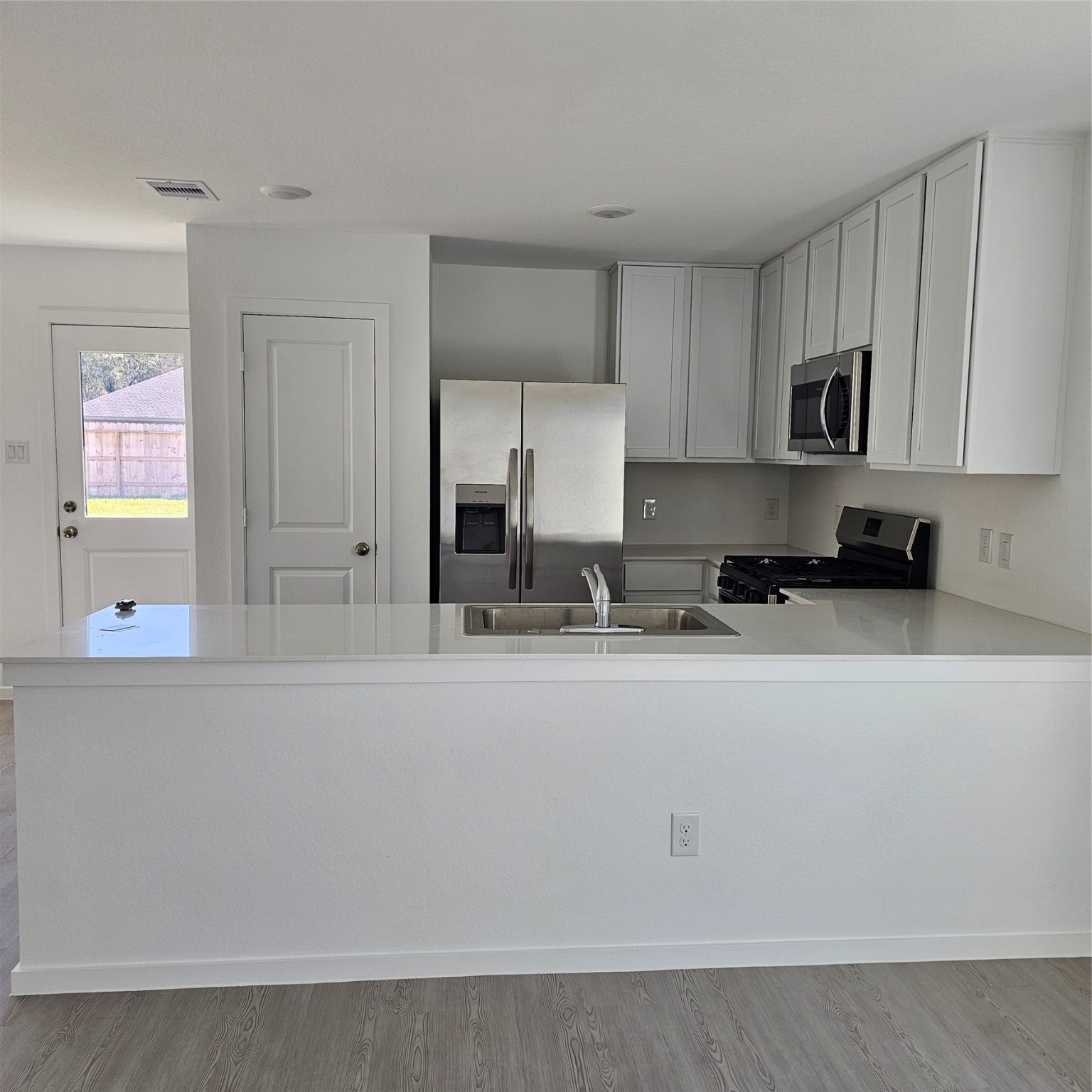 21310 Offida Lane New Caney, TX 77357 - Photo 16 of 24 a kitchen with stainless steel appliances granite countertop a sink a stove and a refrigerator