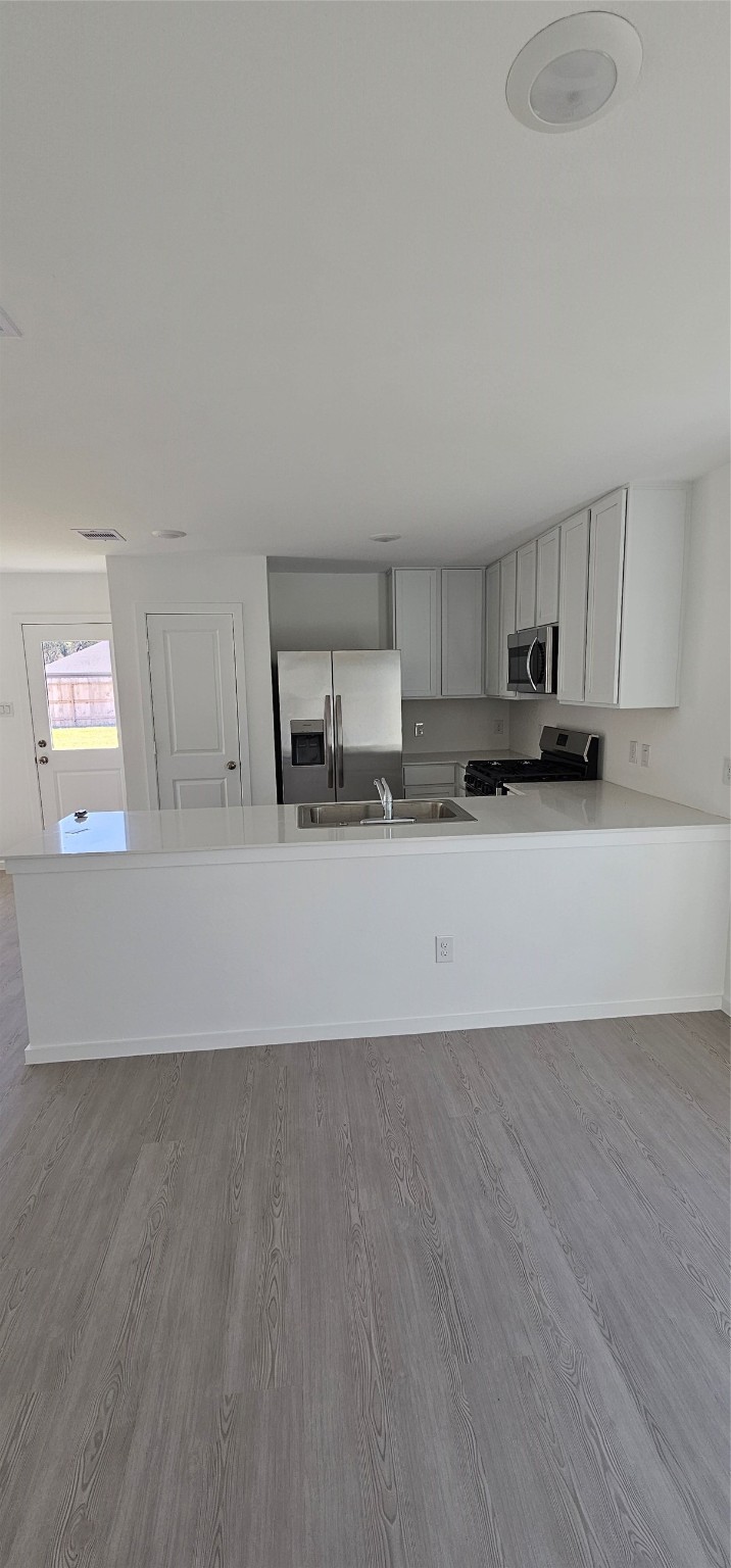 21310 Offida Lane New Caney, TX 77357 - Photo 17 of 24 a view of a kitchen with a sink and dishwasher a stove top oven with wooden floor