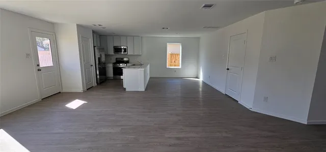 a view of a kitchen with refrigerator and windows