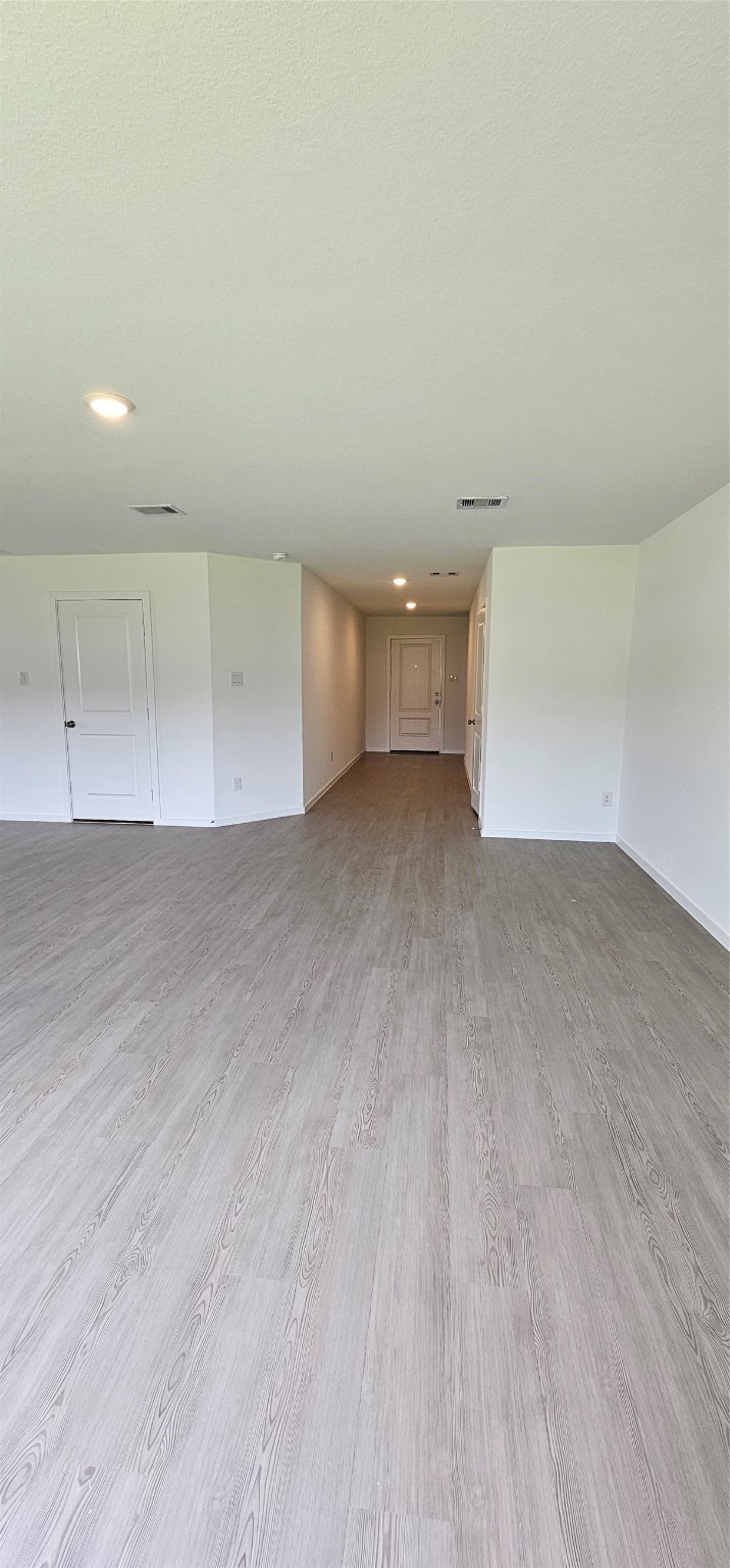 21310 Offida Lane New Caney, TX 77357 - Photo 7 of 24 an empty room with wooden floor and windows