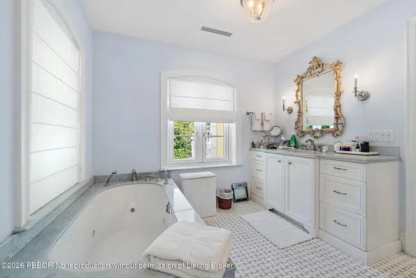 a spacious bathroom with a granite countertop sink a mirror and a bathtub