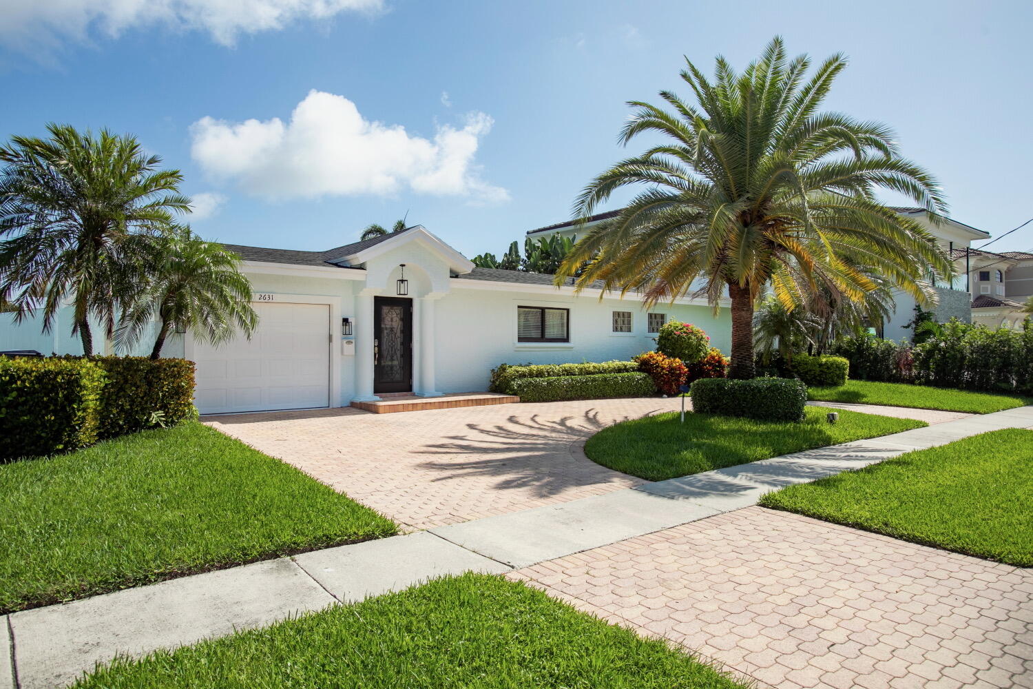 2631 Northeast 48th Street Lighthouse Point, FL 33064 - Photo 22 of 26 a view of a white house with a yard and palm trees