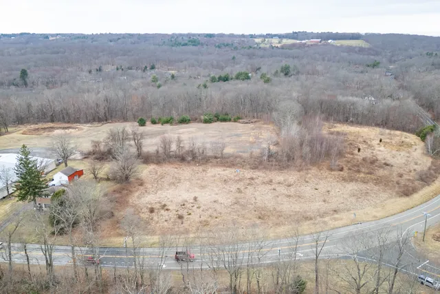 a view of a dry yard with wooden fence