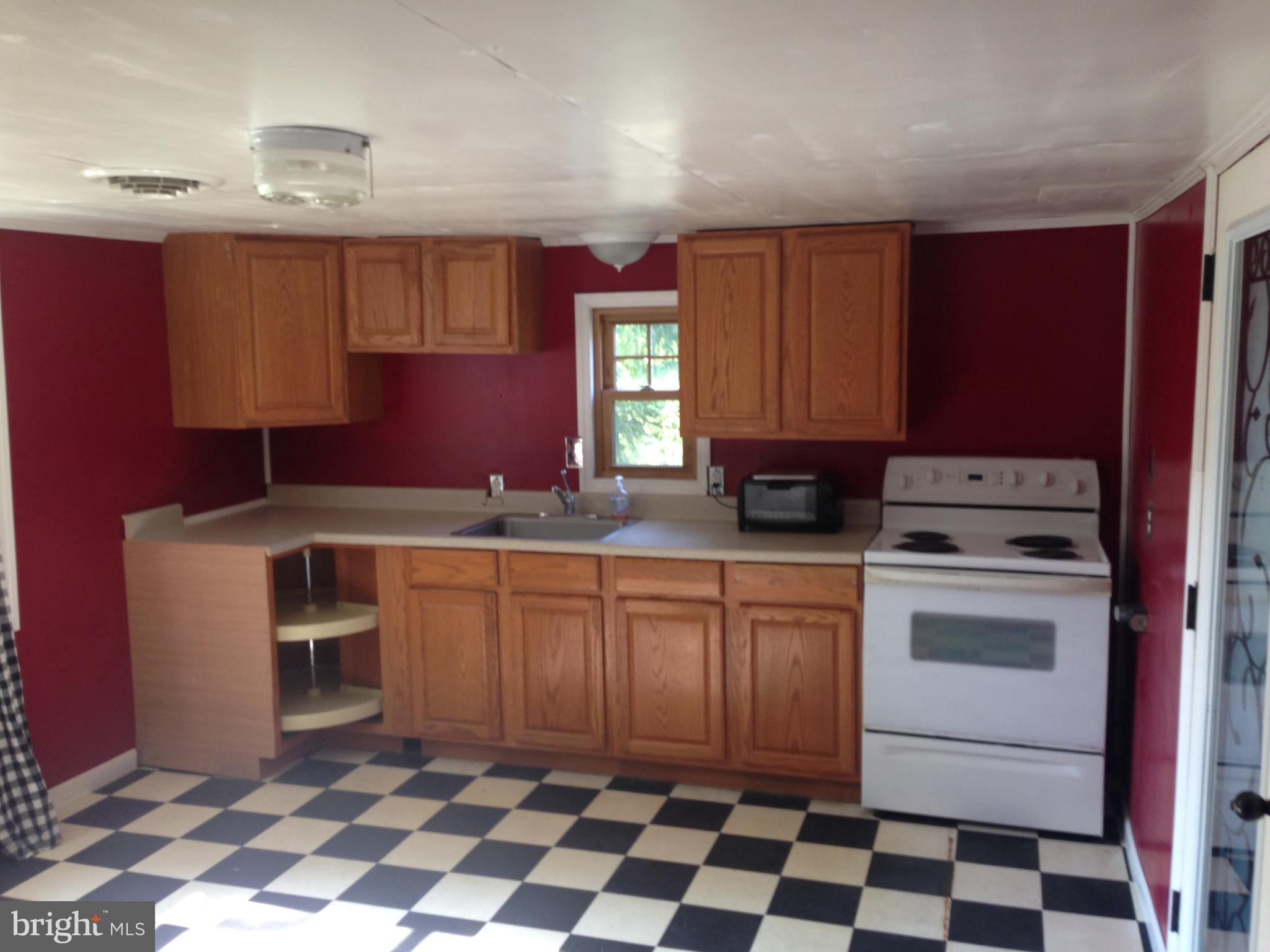 8321 Newark Road Newark, MD 21841 - Photo 5 of 33 a kitchen with a stove a sink and a microwave