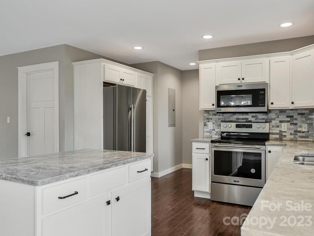 921 Newfound Road Leicester, NC 28748 - Photo 13 of 28 a kitchen with stainless steel appliances kitchen island granite countertop a stove a refrigerator and a microwave