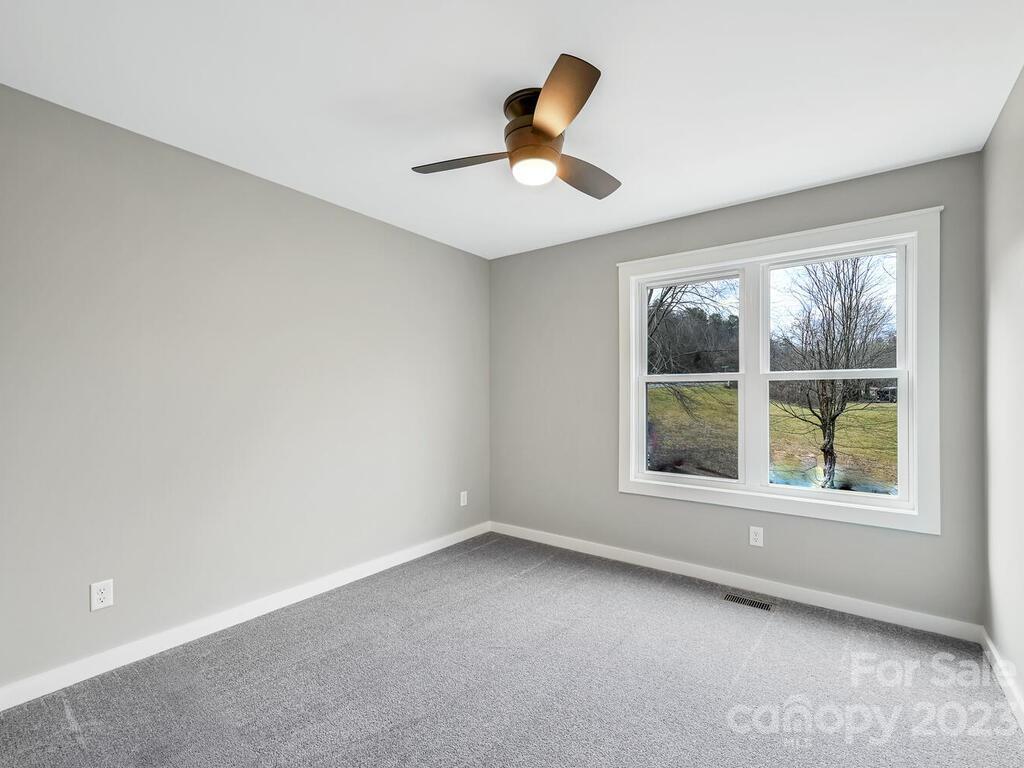 921 Newfound Road Leicester, NC 28748 - Photo 22 of 28 an empty room with a window and a ceiling fan