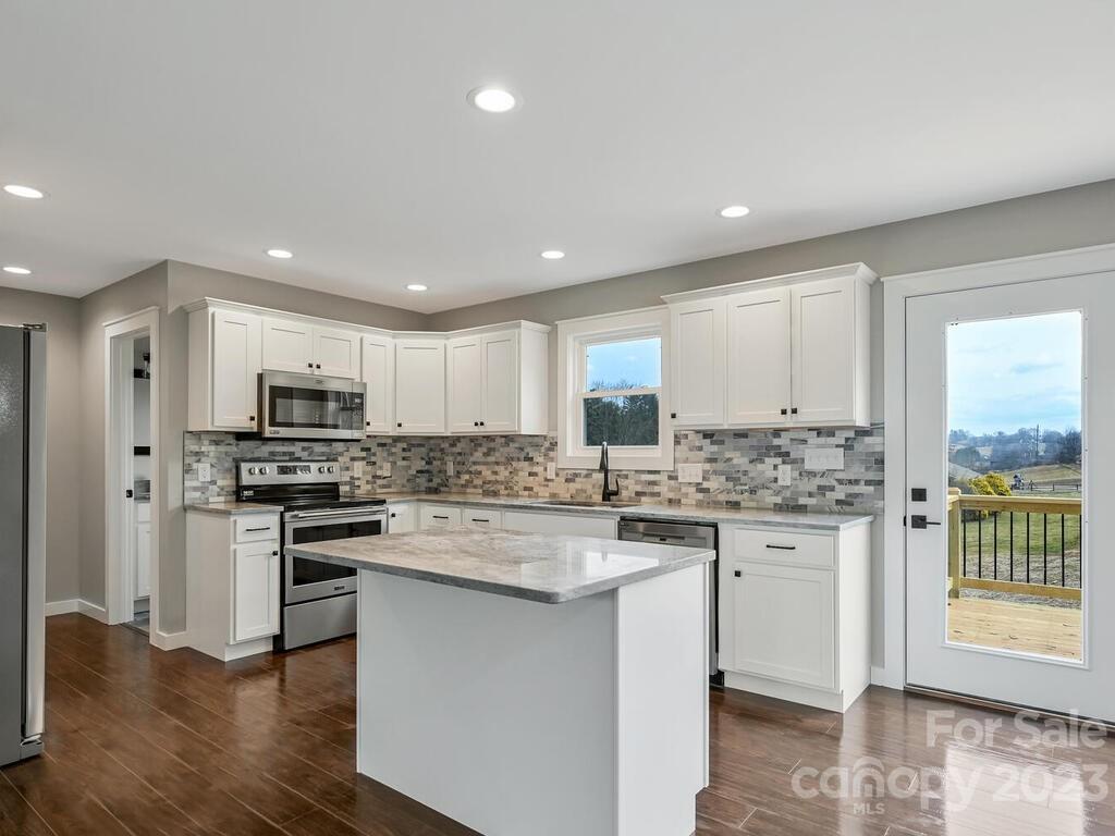 921 Newfound Road Leicester, NC 28748 - Photo 10 of 28 a kitchen with stainless steel appliances granite countertop a stove top oven a sink and a refrigerator
