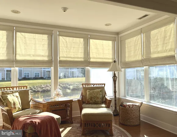 a living room with furniture and floor to ceiling windows