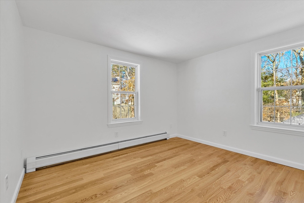 10 Butler Lane Mashpee, MA 02649 - Photo 13 of 42 a view of an empty room with a window and wooden floor