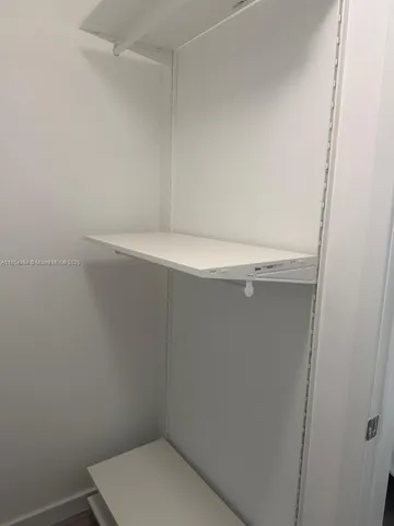 a kitchen with stainless steel appliances kitchen island granite countertop a stove and white cabinets