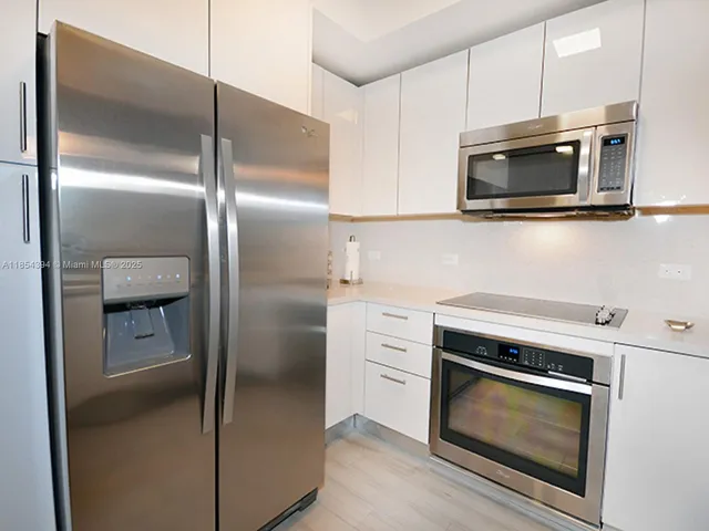 a kitchen with kitchen island a sink appliances and cabinets