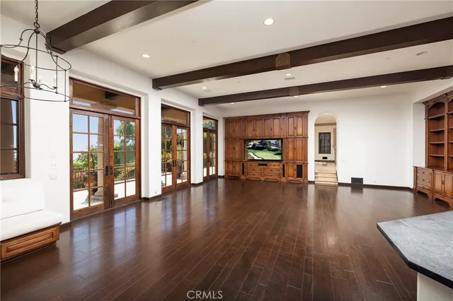 a large kitchen with granite countertop a stove top oven a sink dishwasher a dining table and chairs with wooden floor