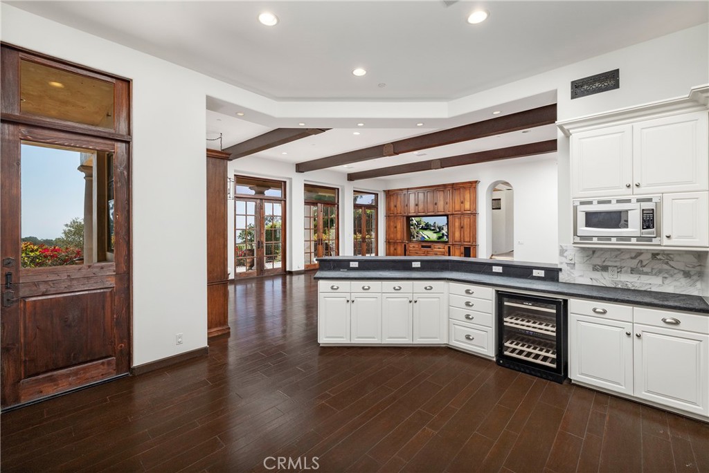 6 Premiere Point Newport Coast, CA 92657 - Photo 12 of 36 a large kitchen with granite countertop a stove top oven a sink dishwasher a dining table and chairs with wooden floor