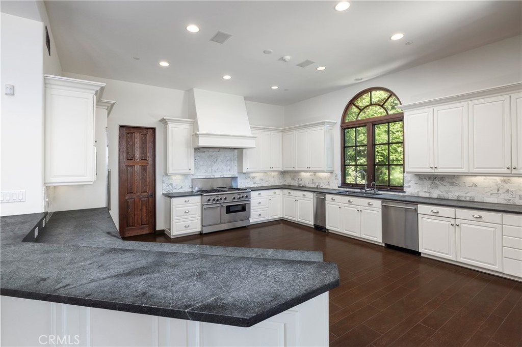 6 Premiere Point Newport Coast, CA 92657 - Photo 13 of 36 a kitchen with stainless steel appliances granite countertop a sink a stove and a wooden floors