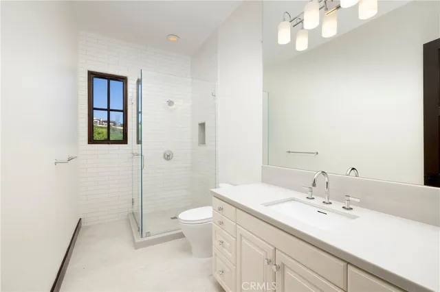 a bathroom with a double vanity sink toilet mirror and shower
