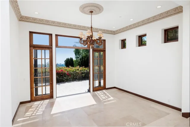 a view of a livingroom with a fireplace a chandelier and windows