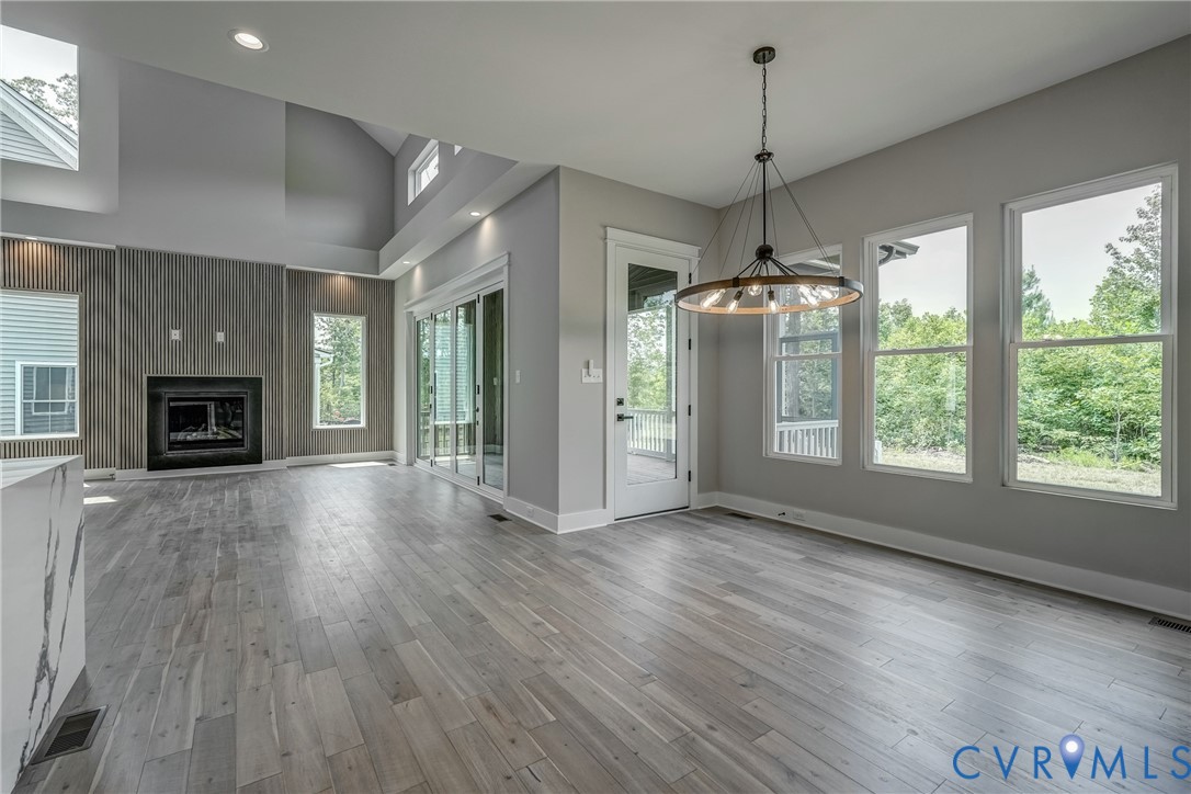 3519 Ampfield Way Midlothian, VA 23112 - Photo 8 of 18 an empty room with wooden floor fireplace cabinet and windows