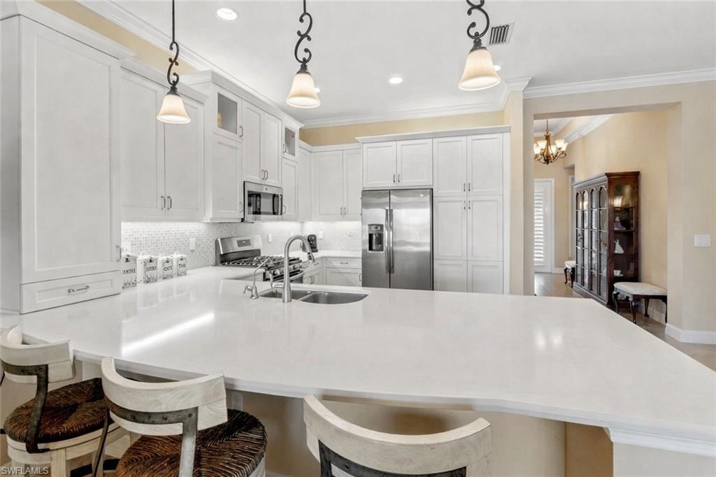 4339 Aurora Street Naples, FL 34119 - Photo 13 of 47 a large kitchen with a table and chairs