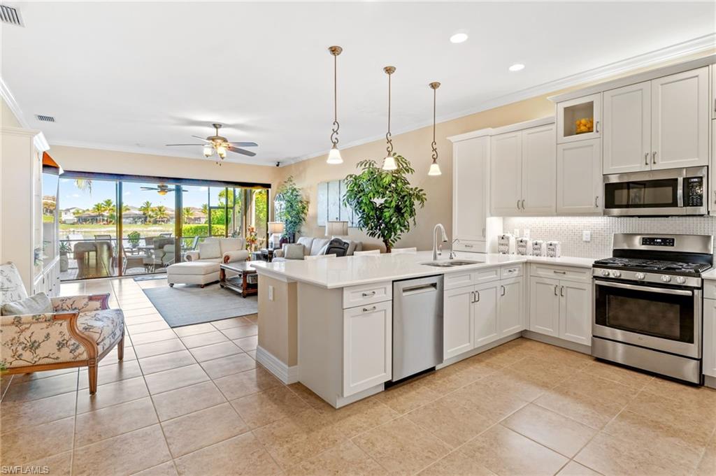 4339 Aurora Street Naples, FL 34119 - Photo 14 of 47 a kitchen with a sink stove and cabinets