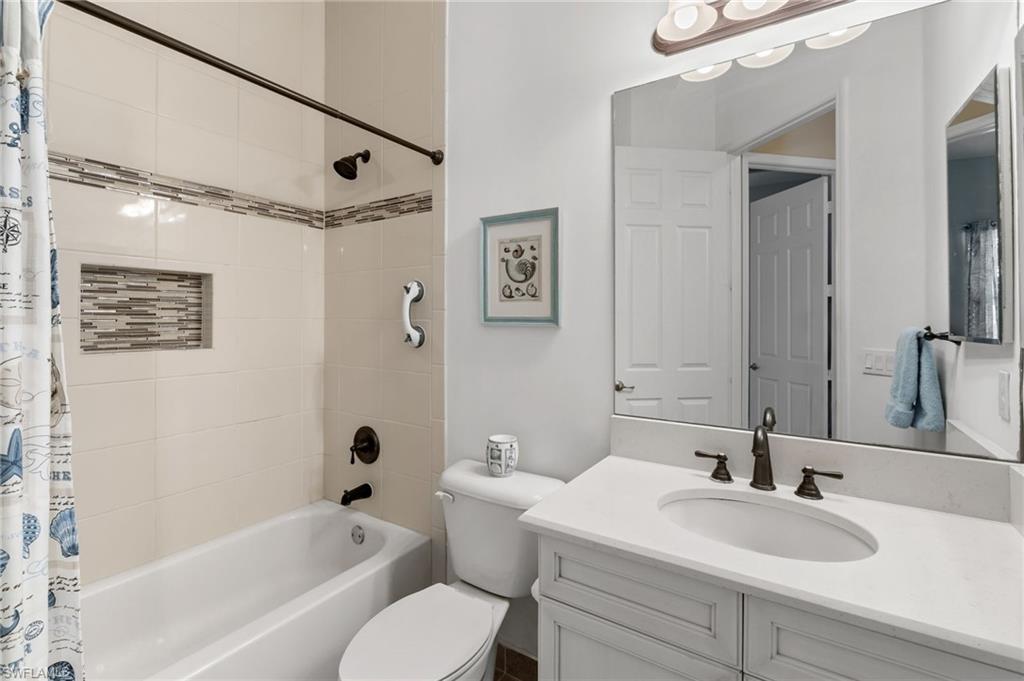 4339 Aurora Street Naples, FL 34119 - Photo 24 of 47 a bathroom with a sink mirror toilet and bathtub