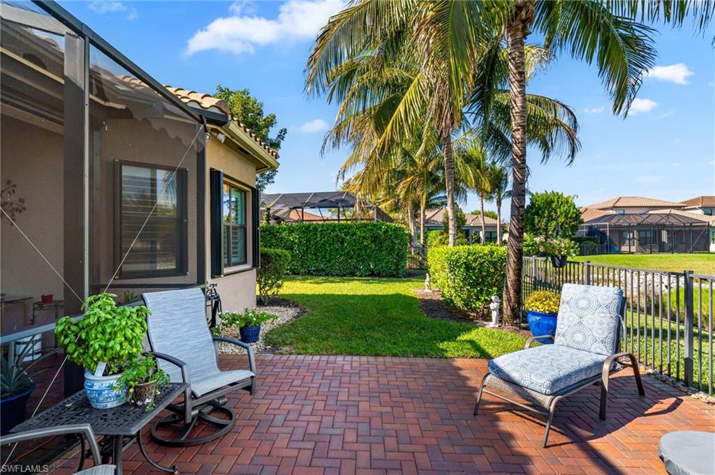4339 Aurora Street Naples, FL 34119 - Photo 32 of 47 a view of a patio with table and chairs potted plants and palm tree