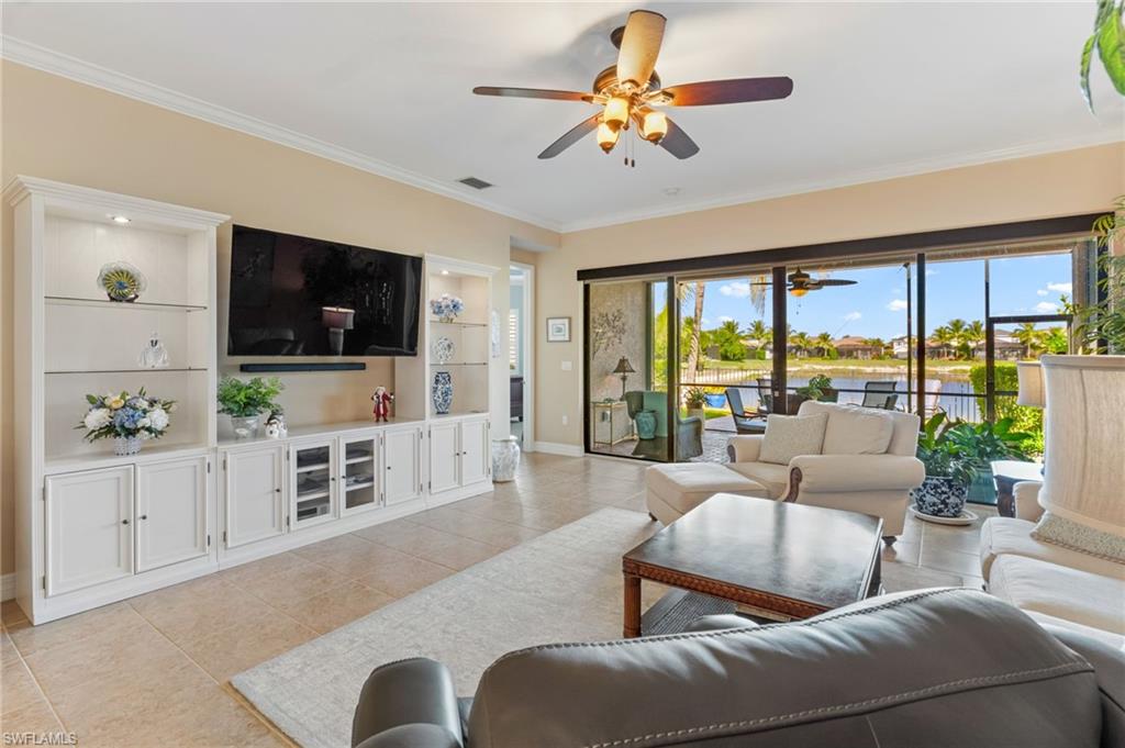 4339 Aurora Street Naples, FL 34119 - Photo 7 of 47 a living room with furniture a flat screen tv and floor to ceiling window
