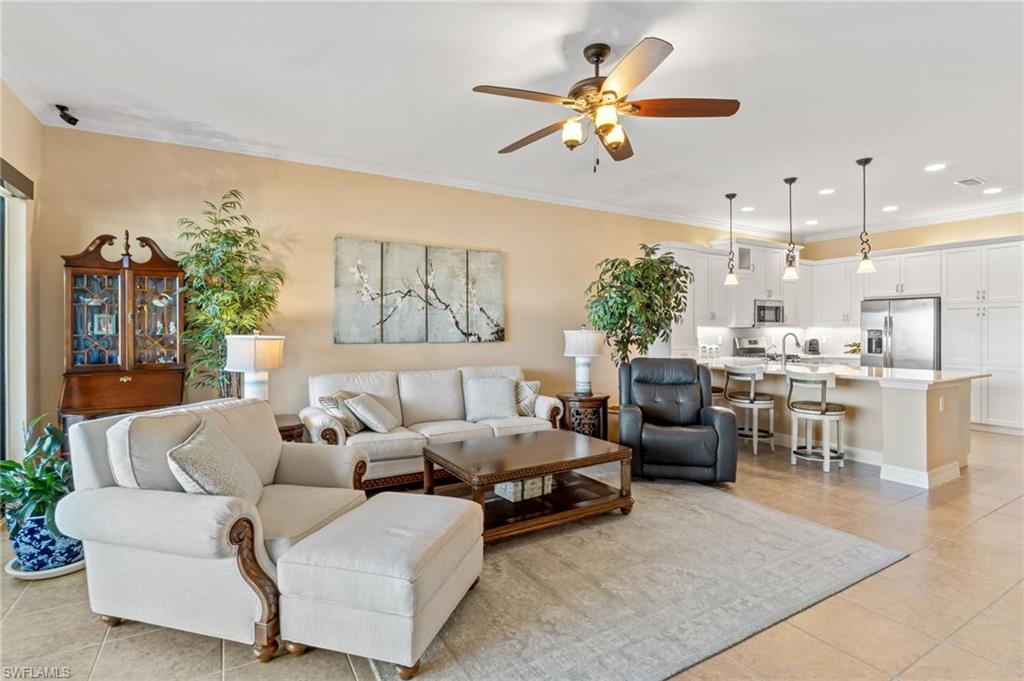 4339 Aurora Street Naples, FL 34119 - Photo 10 of 47 a living room with furniture kitchen view and a chandelier