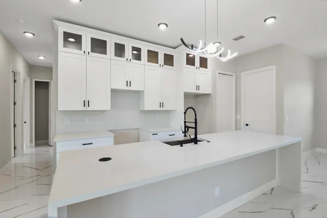 a kitchen with stainless steel appliances a cabinets and chandelier