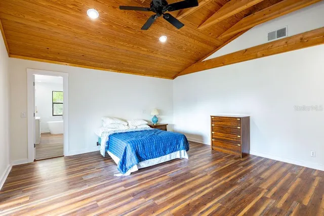 a room with a bed and wooden floor