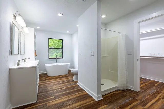 a bathroom with a tub sink shower and mirror