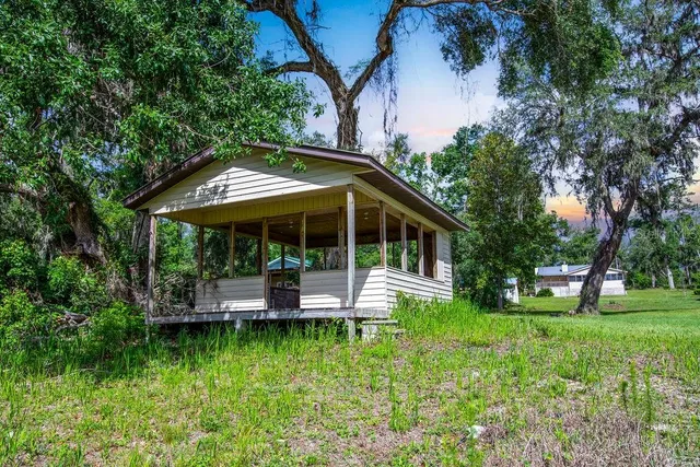 a view of house with backyard and outdoor seating