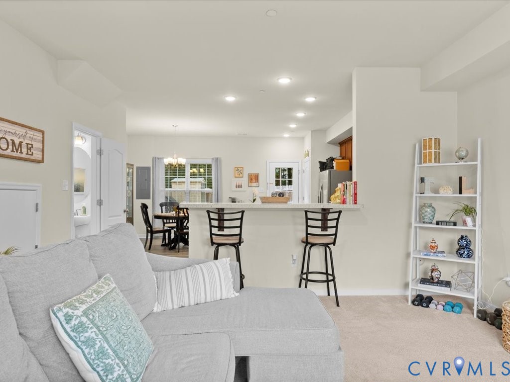 12137 Perdue Springs Loop Chester, VA 23831 - Photo 12 of 45 Living area with a chandelier, light carpet, and r