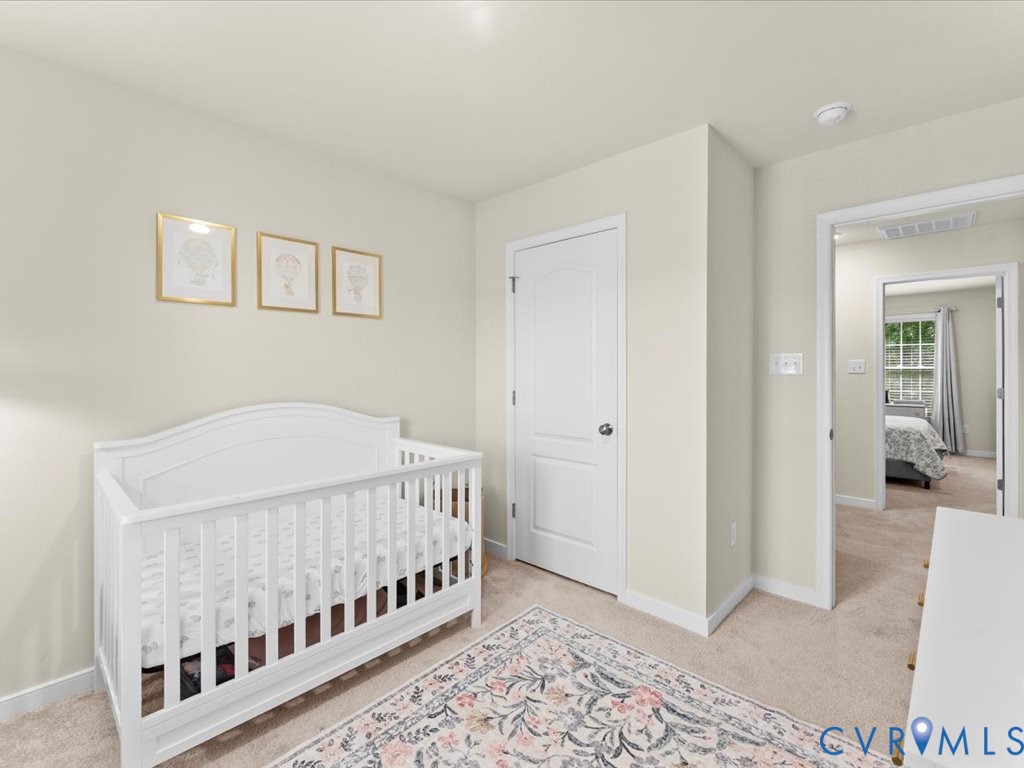 12137 Perdue Springs Loop Chester, VA 23831 - Photo 33 of 45 Bedroom with light carpet and a crib