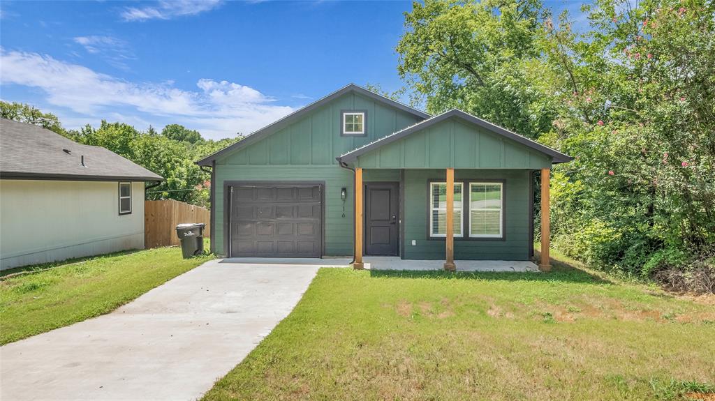 716 East Chestnut Street Denison, TX 75021 - Photo 2 of 26 Contemporary green-sided residence featuring a covered front porch with wood columns and a single-car garage