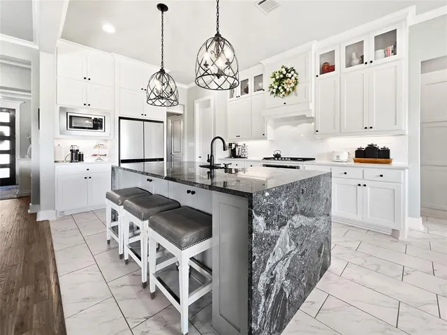 a kitchen with stainless steel appliances granite countertop a sink stove and refrigerator