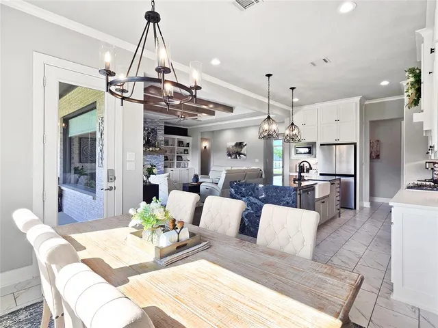 a view of a dining room and livingroom with furniture wooden floor a chandelier