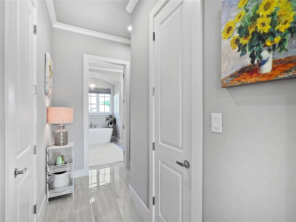 1008 Henry Way Springtown, TX 76082 - Photo 32 of 40 a hallway with a dining table a chandelier and a wooden floor