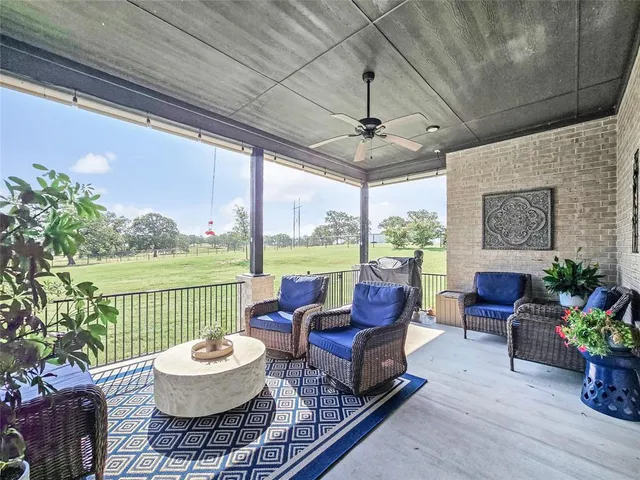 a living room with patio furniture and a potted plant