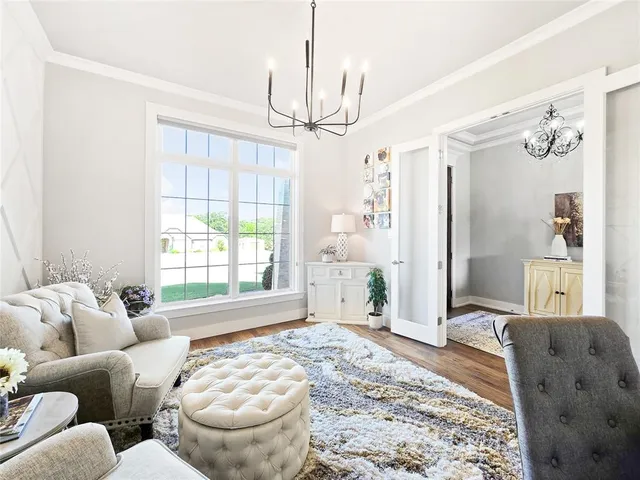 a living room with furniture a chandelier and a window