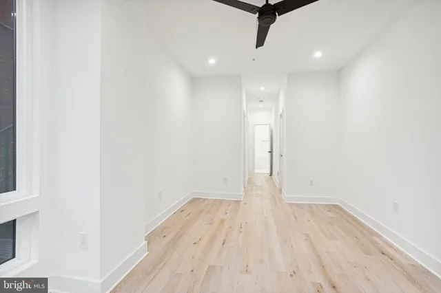 a view of a room with wooden floor and white walls