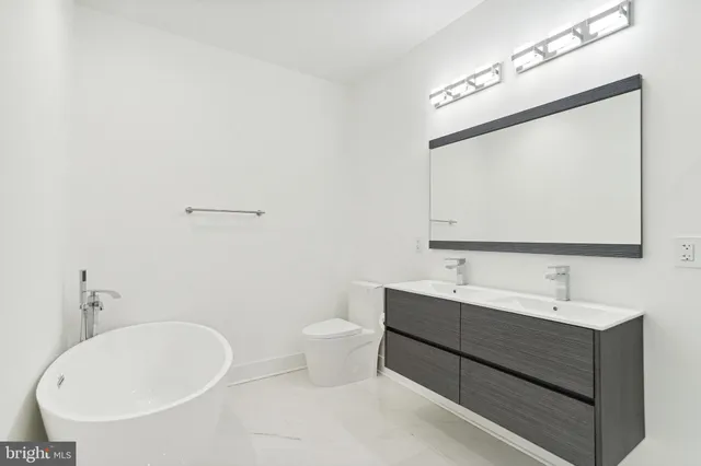 a bathroom with a double vanity sink mirror and toilet