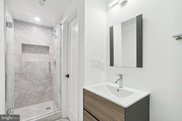 a bathroom with a sink mirror and shower