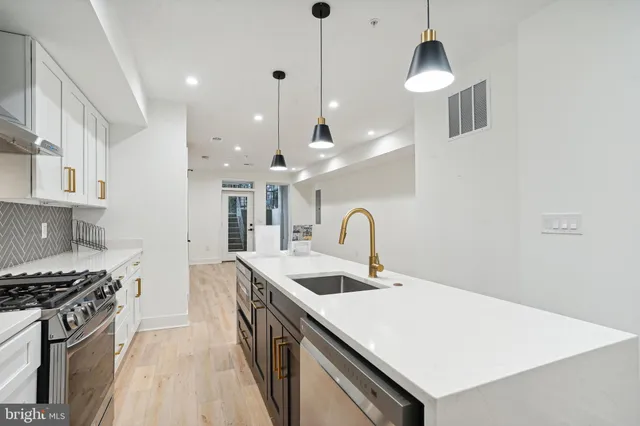 a kitchen with a sink a stove and chairs