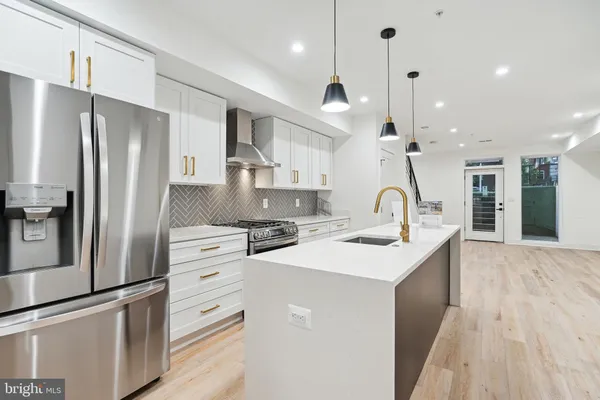 a kitchen with stainless steel appliances a sink stove refrigerator and cabinets