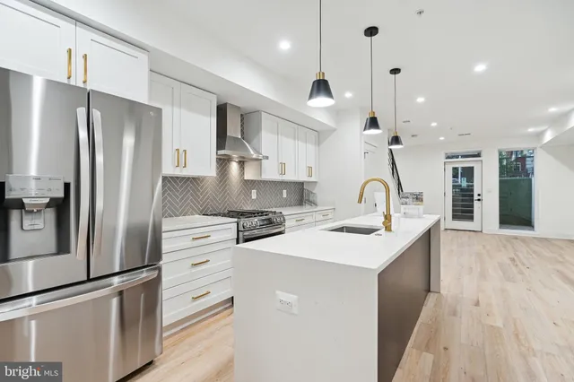 a kitchen with stainless steel appliances a sink stove refrigerator and cabinets