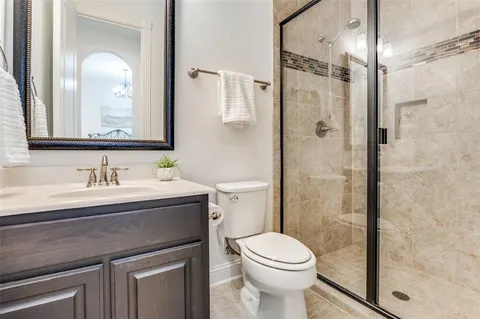 a bathroom with a granite countertop sink mirror vanity and toilet